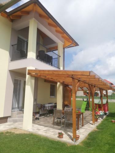 a patio with a wooden pergola in front of a house at Villa Katalino in Gyenesdiás