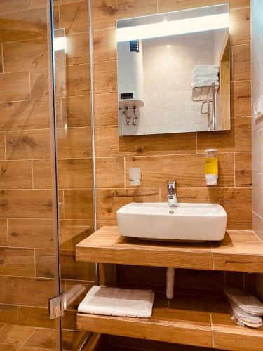 a bathroom with a sink and a mirror at Mykonos Hotel Apart - Maestro in Odesa