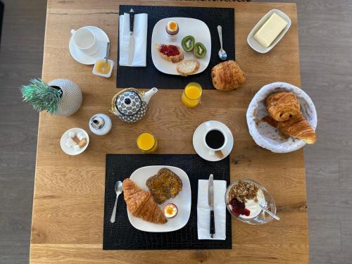 einem Holztisch mit Frühstücksteller darauf in der Unterkunft La Rose des Vents in Le Crotoy