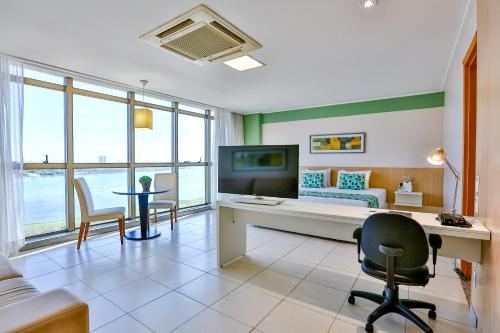 a room with a bed and a desk and a couch at Nobile Suites Del Rio - Petrolina in Petrolina
