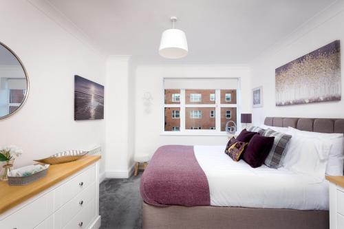 a white bedroom with a large bed and a window at Absolute Stays at The Qube -Utilita-City Center-The Rep-ICC-NIA-Edgbaston Cricket-Free WIFI- Contractors-Sealife-BrindleyPlace in Birmingham