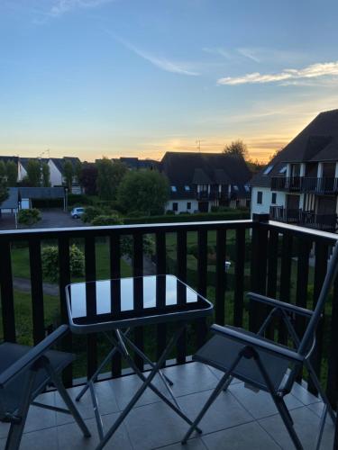 a table and two chairs on a balcony at Escapade à Cabourg, 300M plage, calme et chaleureux in Cabourg