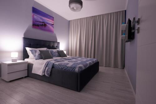 a bedroom with a king sized bed and a window at Atlantis Apartment in Mamaia Sat/Năvodari