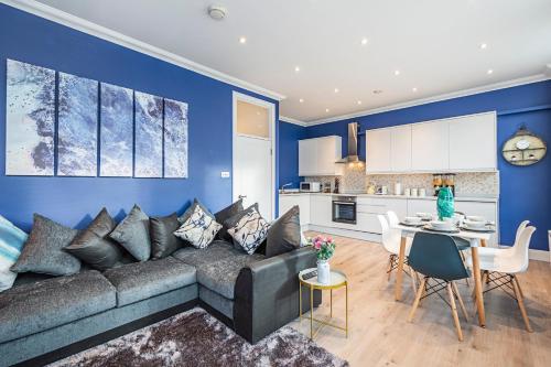 ein blaues Wohnzimmer mit einem Sofa und einem Tisch in der Unterkunft Instagram-Worthy apartment in Central London in London