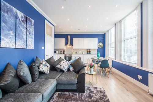 ein Wohnzimmer mit einem Sofa und einer blauen Wand in der Unterkunft Instagram-Worthy apartment in Central London in London