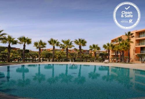 a large swimming pool in front of a resort at Herdade dos Salgados Beach apartment in Albufeira