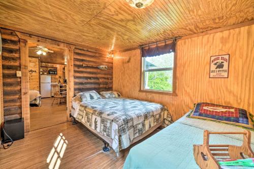 a bedroom with two beds in a log cabin at Rustic Davis Cabin Less Than half Mile to Turner Falls! in Davis