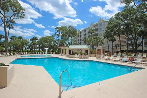 a swimming pool with lounge chairs and a hotel at Windsor II in Hilton Head Island