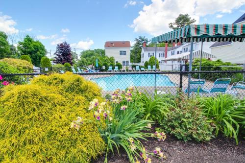 Un jardín con flores y una piscina. en The Holiday House Condominiums, en Wells