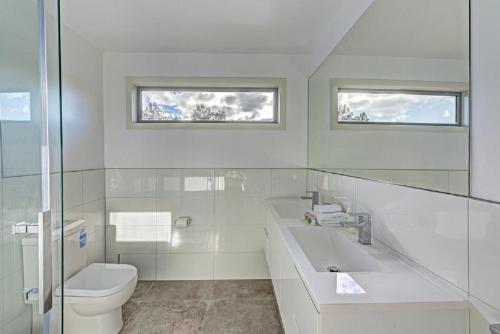 a white bathroom with a sink and a toilet at Deja Blu 2 in Coles Bay