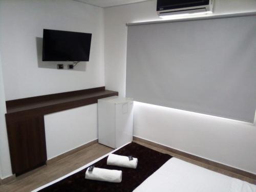 Kleines Zimmer mit einem TV und 2 Handtüchern. in der Unterkunft Jardin de Laureles in Medellín