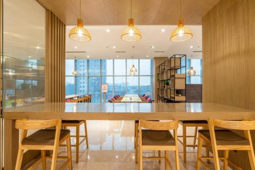 a large dining room with a large wooden table and chairs at Holiday Inn Express Anshan Downtown, an IHG Hotel in Anshan