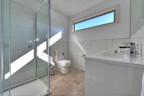 a bathroom with a shower and a sink and a toilet at Deja Blu 1 in Coles Bay
