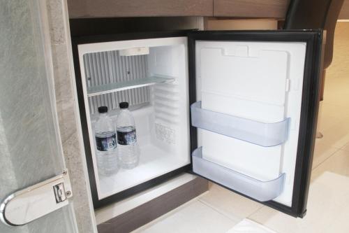 an open refrigerator with two bottles of water in it at Gamalan Spring Hotel in Jiaoxi