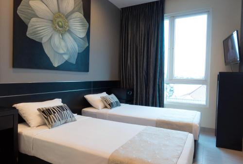 a hotel room with two beds and a window at Hotel 81 Changi in Singapore