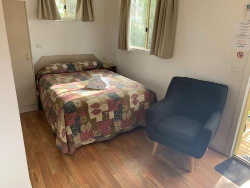 a bedroom with a bed and a chair at Horsham Riverside Caravan Park in Horsham