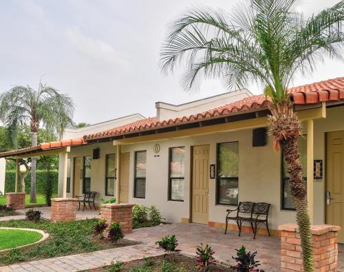a house with a palm tree in front of it at The Bungalows on Shary in McAllen