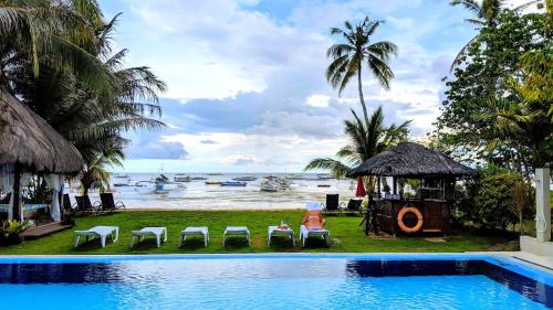 a resort swimming pool with a view of the ocean at Bohol South Beach Hotel in Panglao