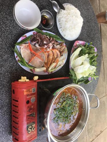 a table with a bowl of food and a bowl of rice at Nhà nghỉ Cát Đằng Hồ Tràm in Ho Tram