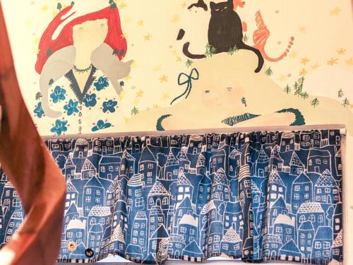 a curtain with a woman and a cat on top of it at Red Letter Day in Tainan