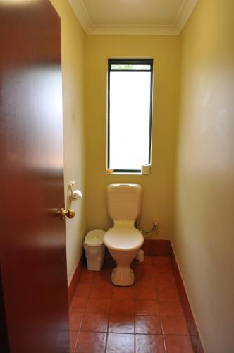 a bathroom with a toilet and a window at Karri Valley Chalets in Pemberton