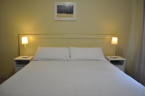 a bedroom with a large bed with two lamps on both sides at Karri Valley Chalets in Pemberton