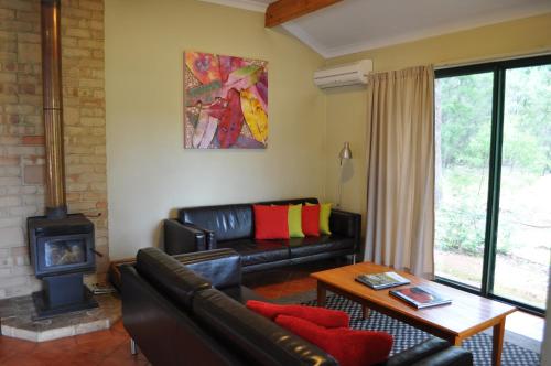 a living room with a couch and a wood stove at Karri Valley Chalets in Pemberton