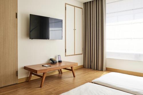 a hotel room with a table and a television at Hotel NewV in Seoul