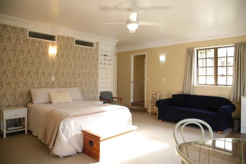 a bedroom with a bed and a couch at Somersal Bed & Breakfast in Pirongia