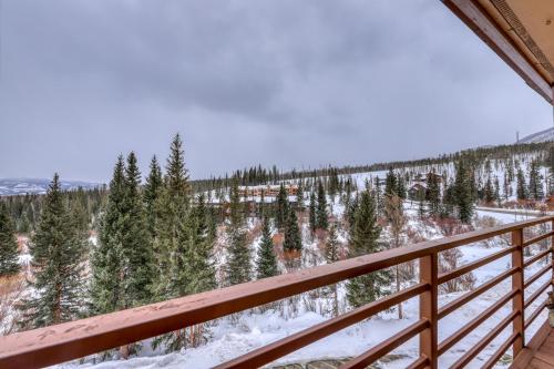 a view from the balcony of a house with snow covered trees at Buffalo Ridge Condos in Silverthorne