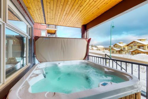 un jacuzzi en el balcón de una casa en Raven 104, en Big White