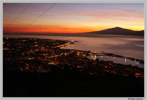 a view of a city at sunset with a mountain at Hotel Continental in Reggio Calabria