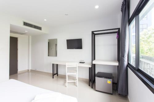a white room with a desk and a window at The Gene in Krabi town