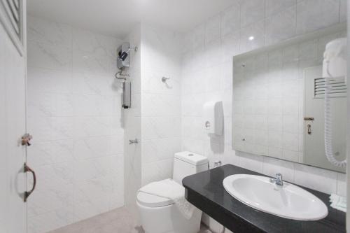 a white bathroom with a sink and a toilet at The Gene in Krabi town