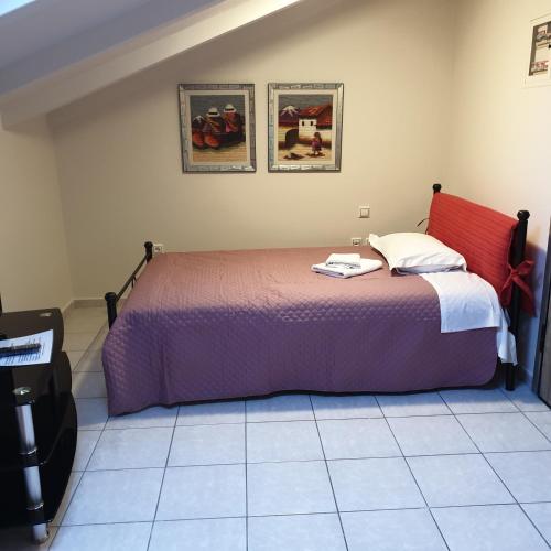 a bedroom with a large bed with a purple blanket at Alexia's Apartments in Rio