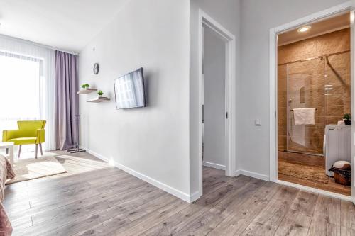 Sala de estar blanca con puerta corredera de cristal en Raisson Ahotel D86 en Astaná