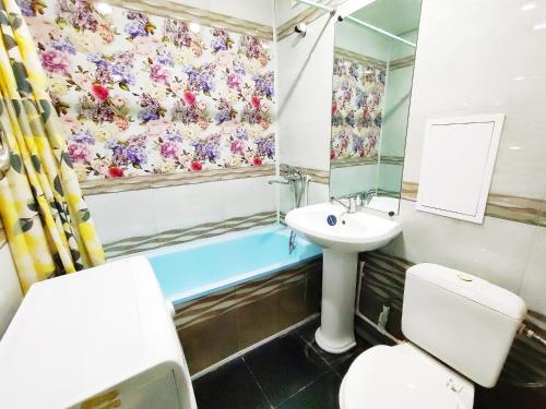 a bathroom with a sink and a toilet and a tub at Апартаменты на Сайдашева 3 in Bugul'ma