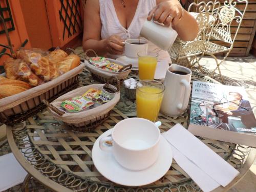 a woman sitting at a table with a tray of breakfast food at Hôtel Beaunier in Paris