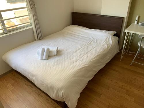 a large white bed with two towels on it at 交通アクセス便利! 9min from susukino station すすきの駅から歩いて9分 島屋ビル 505号室 in Sapporo