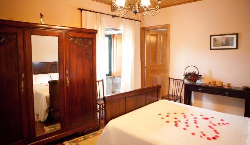 a bedroom with a bed with red rose petals on it at Casa de Barreiro in Teijeiro