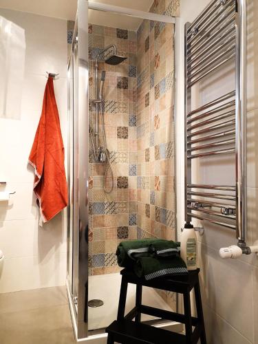 a bathroom with a shower and a stool with a mirror at La CasAffittiera Apartments Group in Anzio