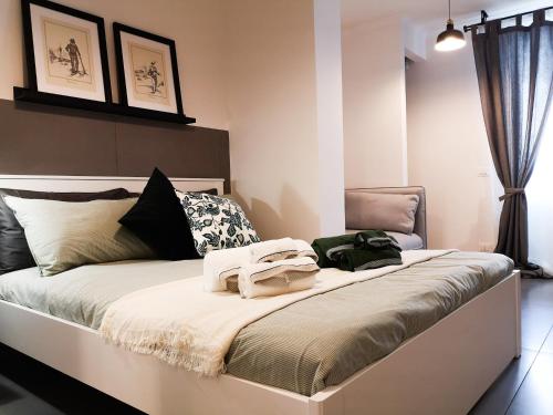 a bedroom with a large bed with towels on it at La CasAffittiera Apartments Group in Anzio