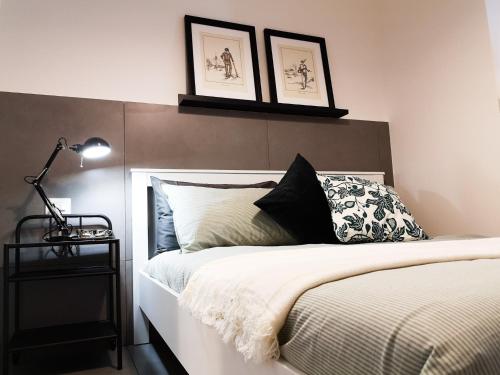 a bedroom with a bed with two pictures on the wall at La CasAffittiera Apartments Group in Anzio