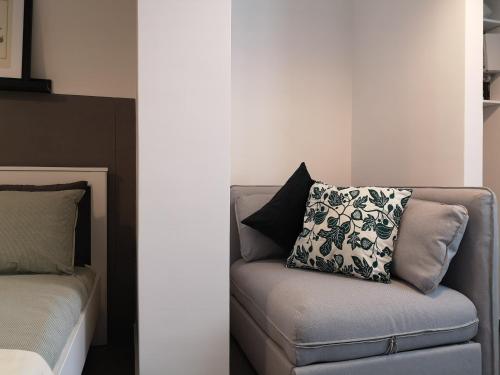 a couch with a pillow on it next to a bed at La CasAffittiera Apartments Group in Anzio