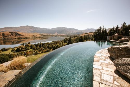 a swimming pool with a view of a river and mountains at Stoneridge Estate in Queenstown