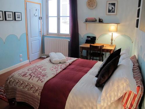 Un dormitorio con una cama grande con almohadas. en B&B in Arles "L'Atelier du Midi" chambre d'hôtes centre historique ARLES, en Arles