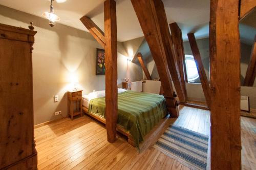 a bedroom with a bed in a room with wooden beams at Malpils Manor in Mālpils
