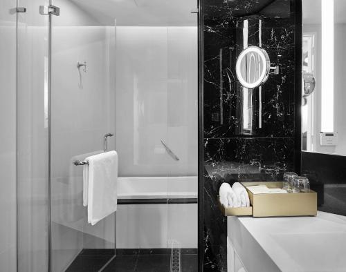 a bathroom with a shower and a sink with a mirror at Grande Centre Point Sukhumvit 55 Thong Lo in Bangkok