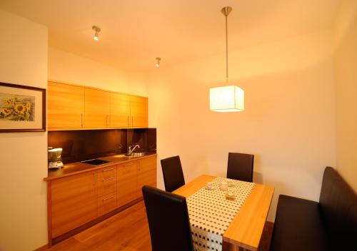 a dining room with a table and a kitchen at Apparthotel Gartenresidence Nalserhof in Nalles