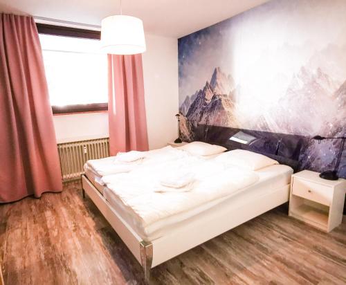 - une chambre avec un lit orné d'une peinture murale dans l'établissement Apartments Golfhof, à Winterberg